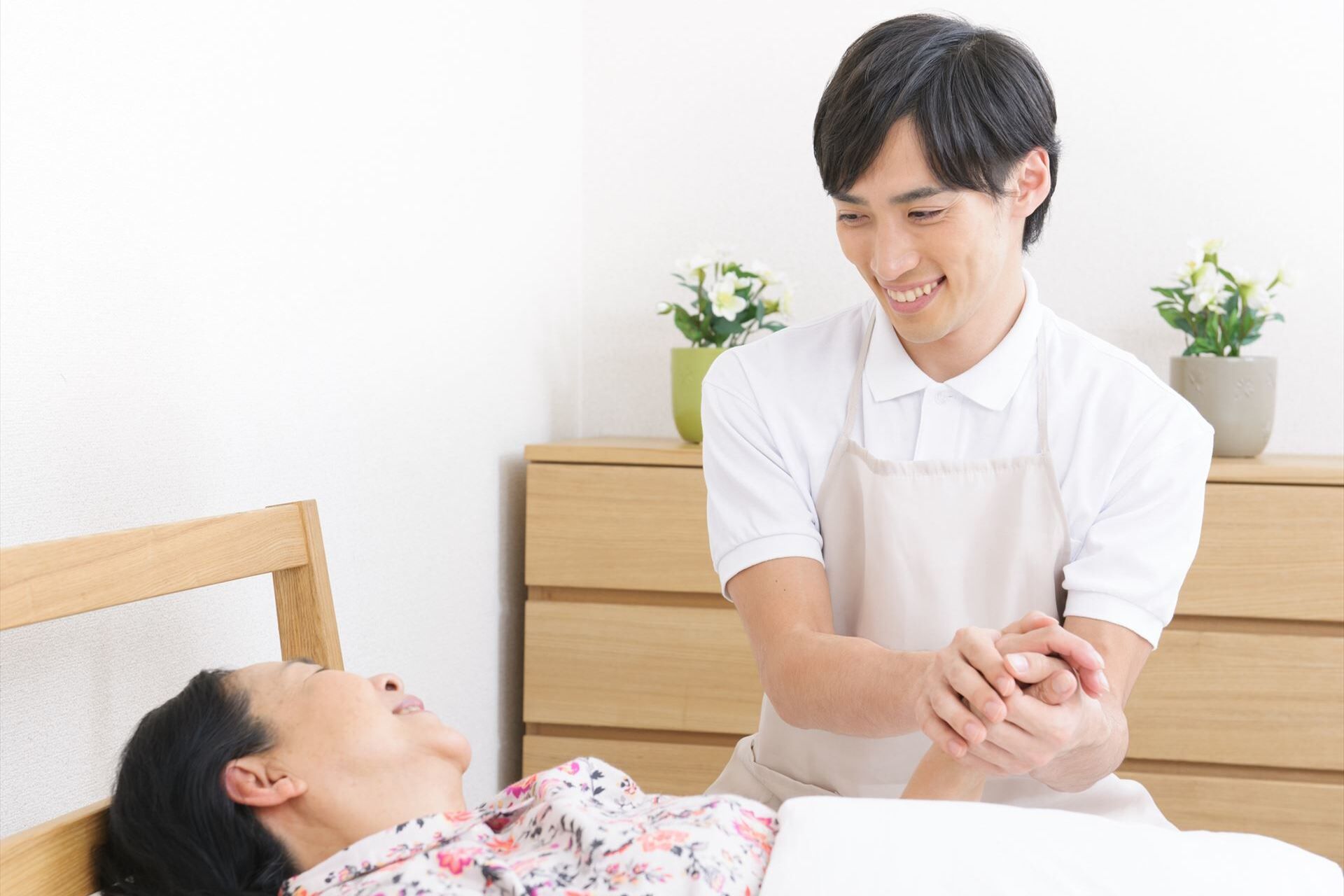 女性の手を握る男性スタッフ